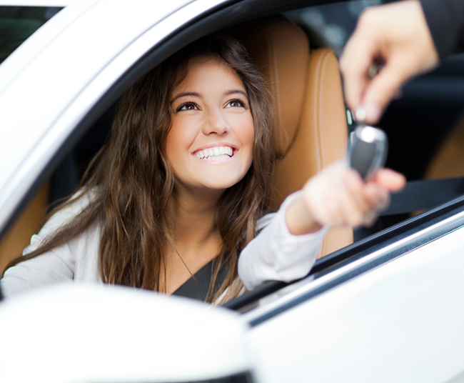 Woman getting keys to new car.